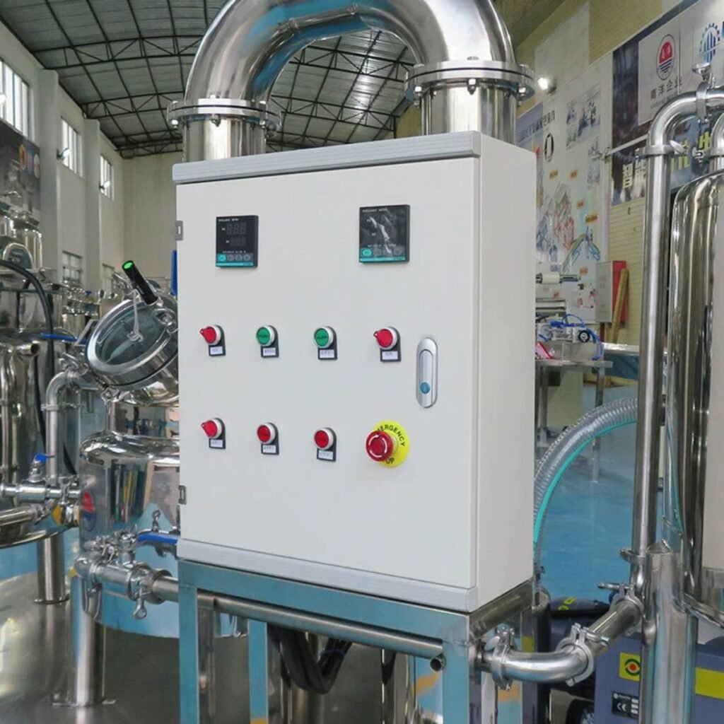 Control panel of honey processing line showing PLC/HMI screens, indicator lights, emergency stop, and sanitary 304SS piping — BuzzBeeEquip