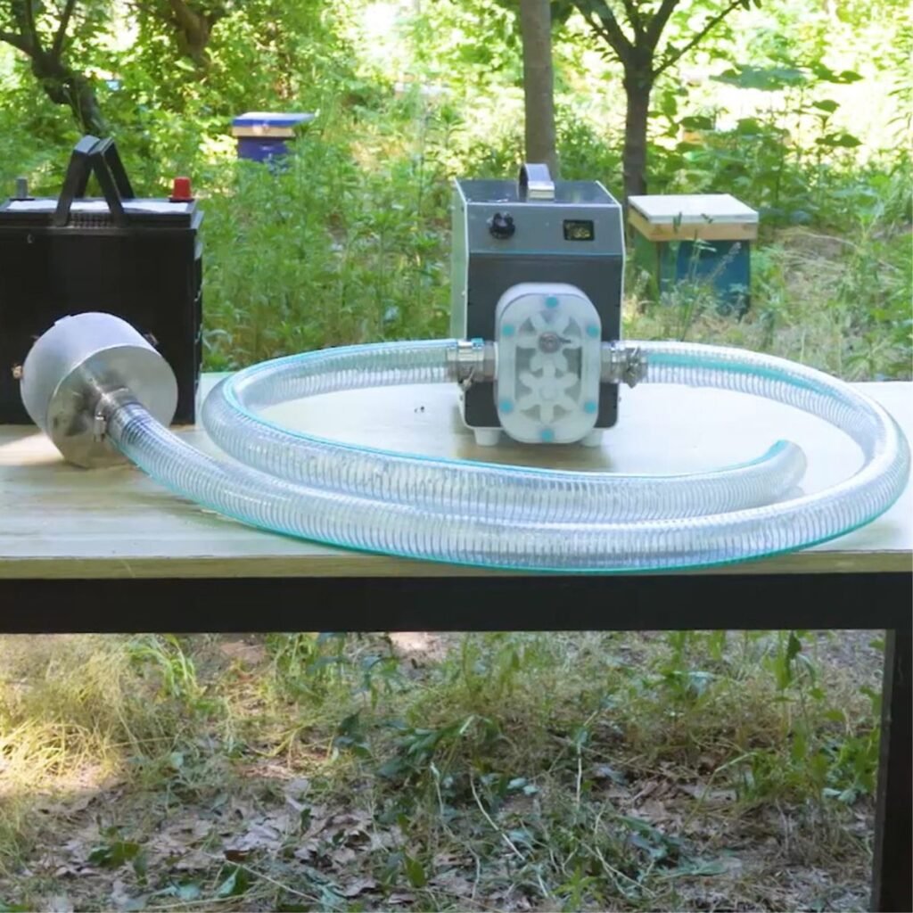 Honey filter transfer pump operating in the apiary, filtering and moving honey through clear hoses